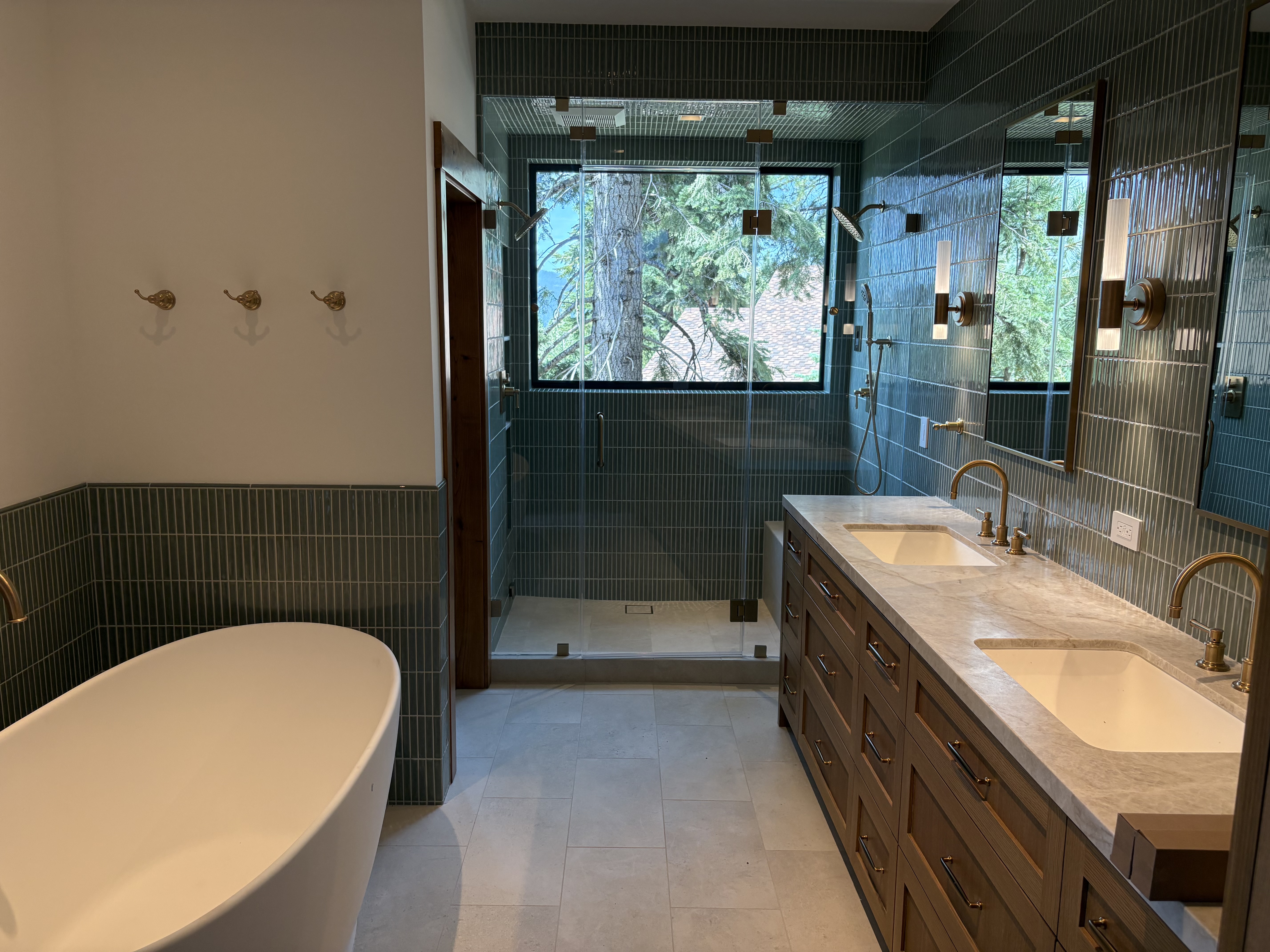 Green tiled custom bathroom with double vanity and shower